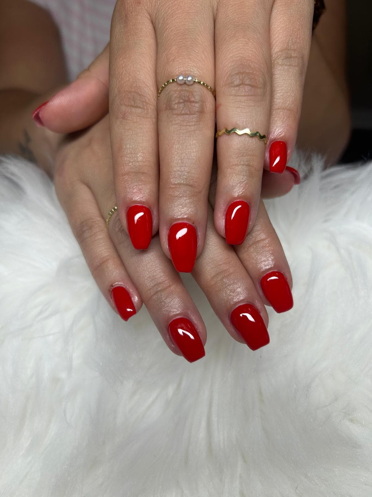 Esmalte en gel rojo intenso en uñas cuadradas.
